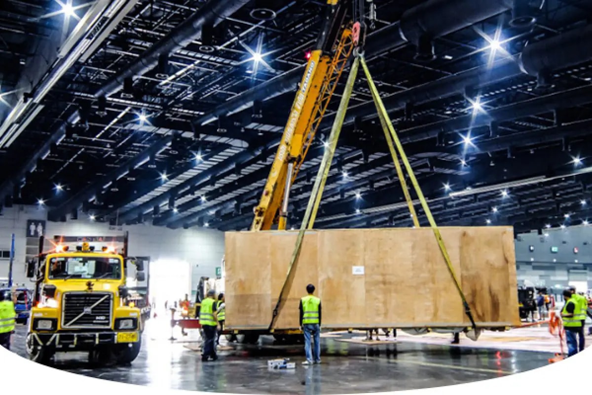 Maxline Global team handling exhibition cargo with booths and crates at an event venue